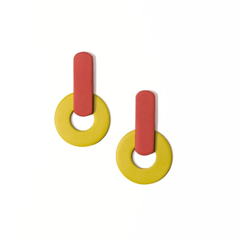 A pair of earrings featuring geometric shapes with terracotta and lime green colors, made from buffalo horn with a stainless steel ear post.