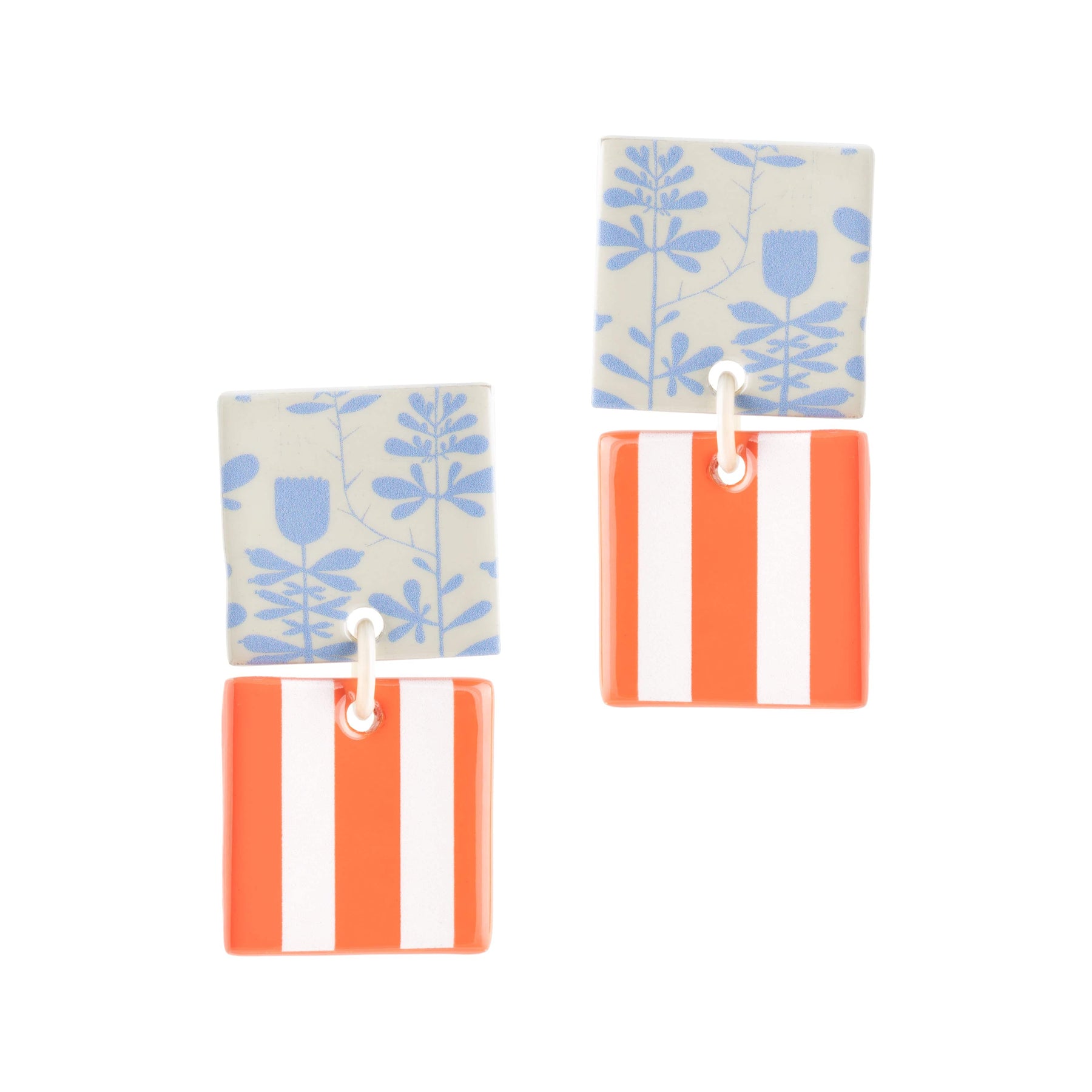 A pair of drop earrings featuring light blue floral patterns and bold red stripes on a cream background.