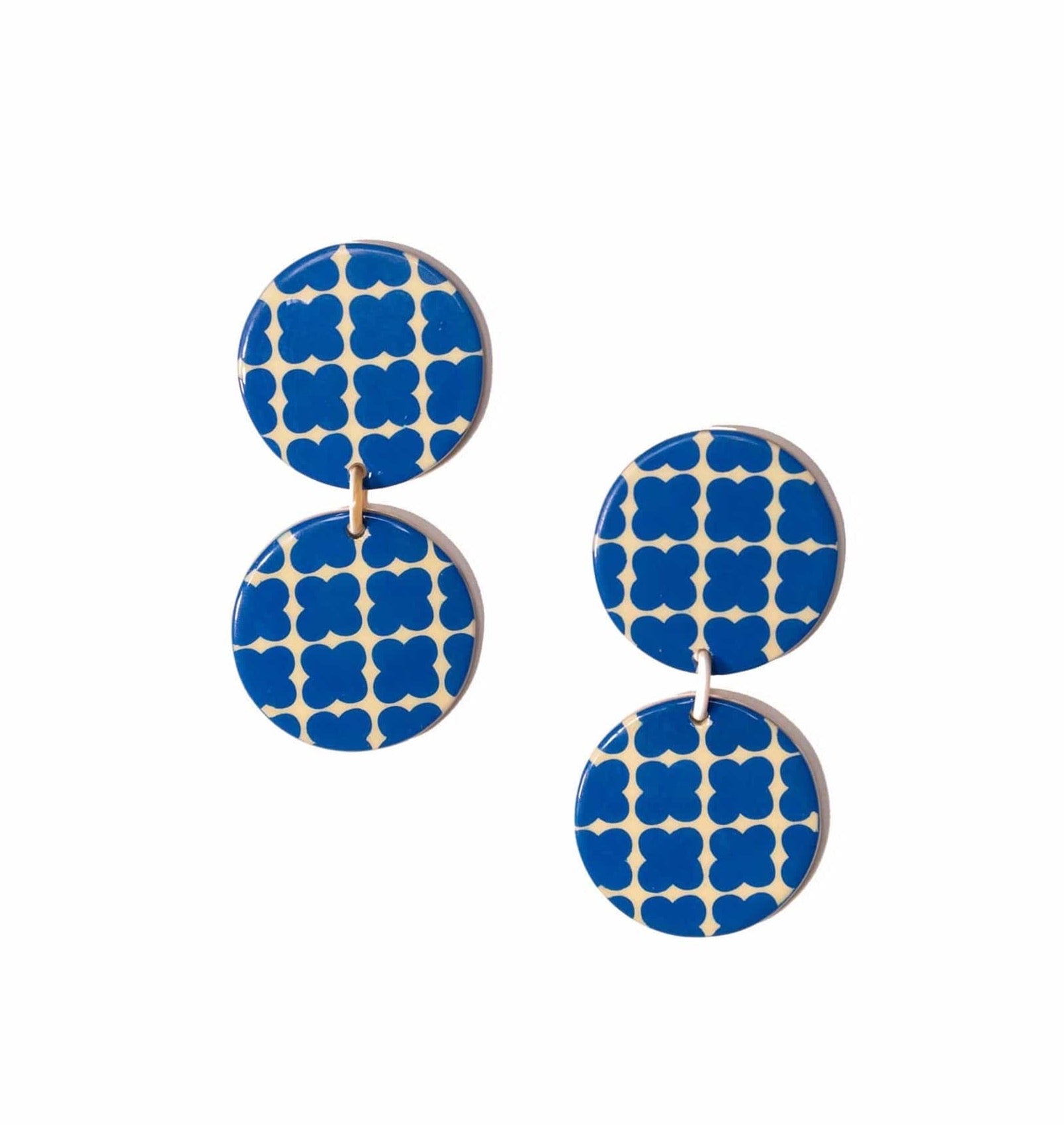 A pair of blue and white geometric patterned earrings made from buffalo horn, displayed against a white background.