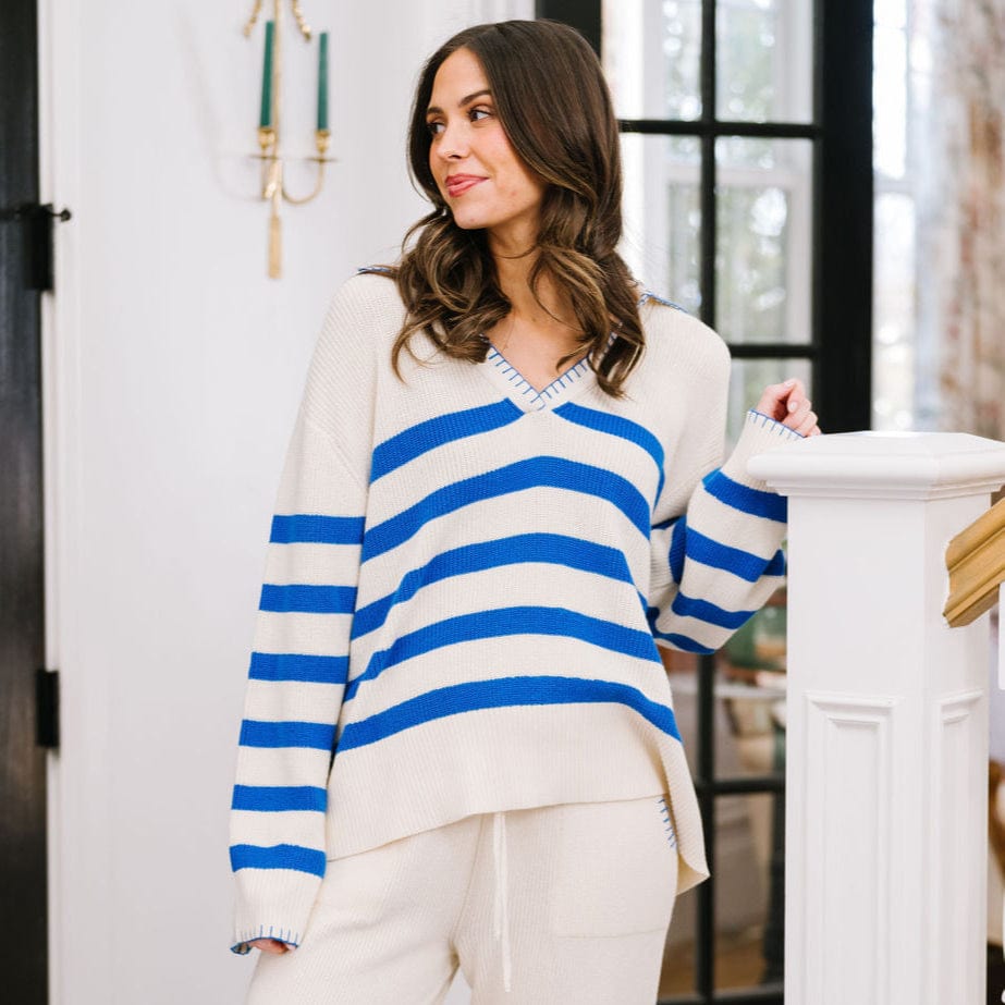 Woman wearing a blue and white striped sweater in a home setting
