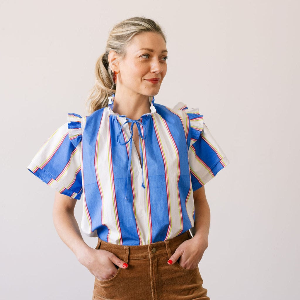 Woman wearing a colorful striped shirt with a plain background