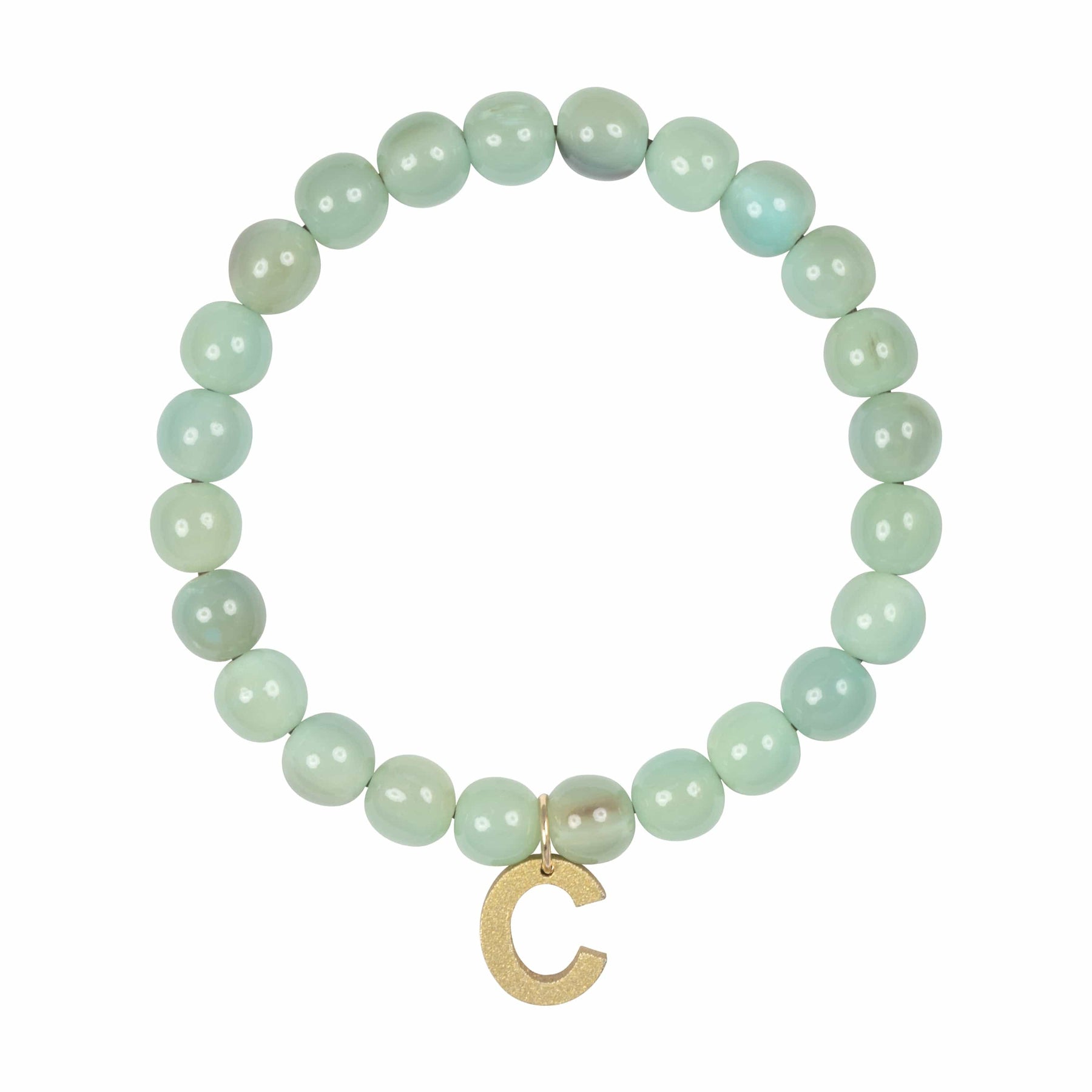 A green bead bracelet with a gold charm in the shape of the letter 'C'.