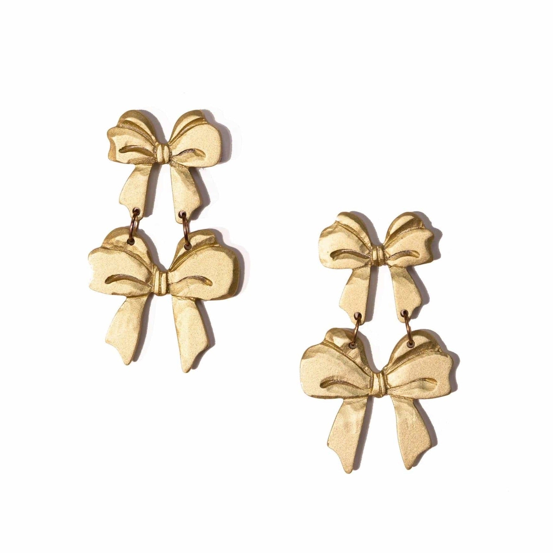 A pair of metallic gold double bow earrings with dangle design on a white background.