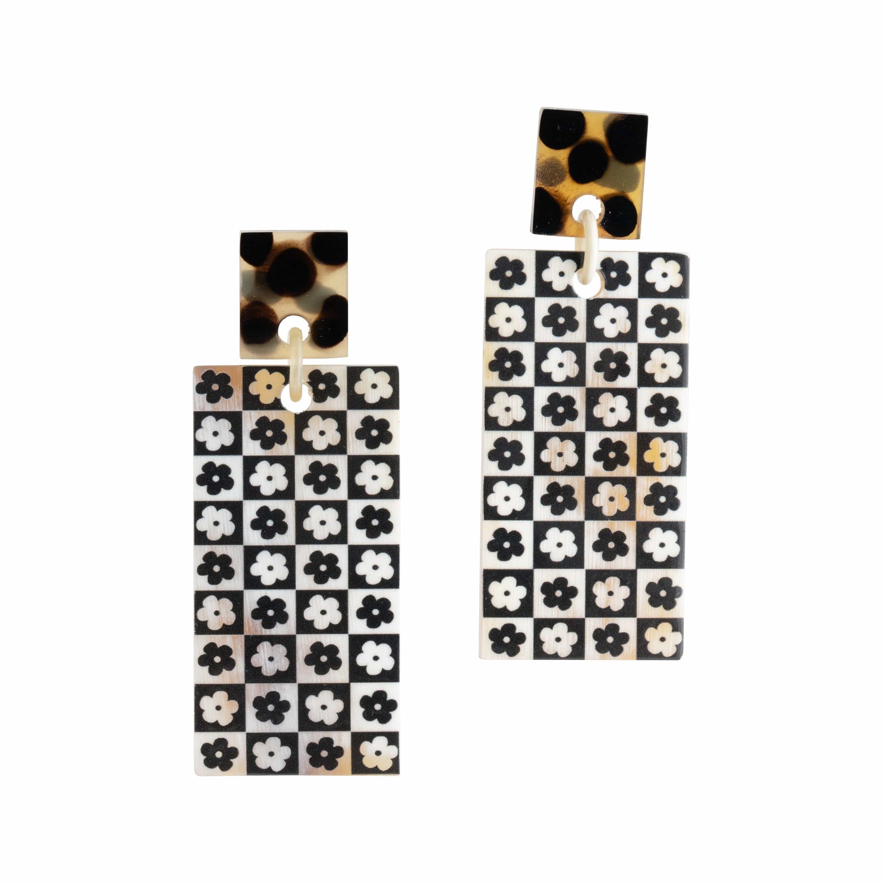 A pair of black and white checkered pattern earrings with a floral design, made from buffalo horn with a stainless steel ear post.