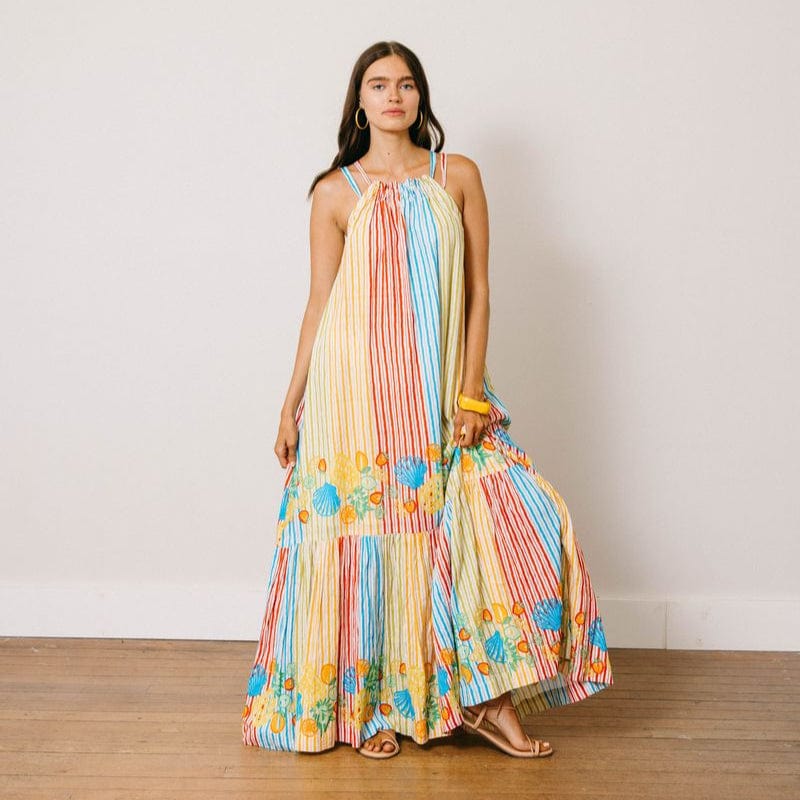 Woman wearing a colorful patterned dress on a plain background