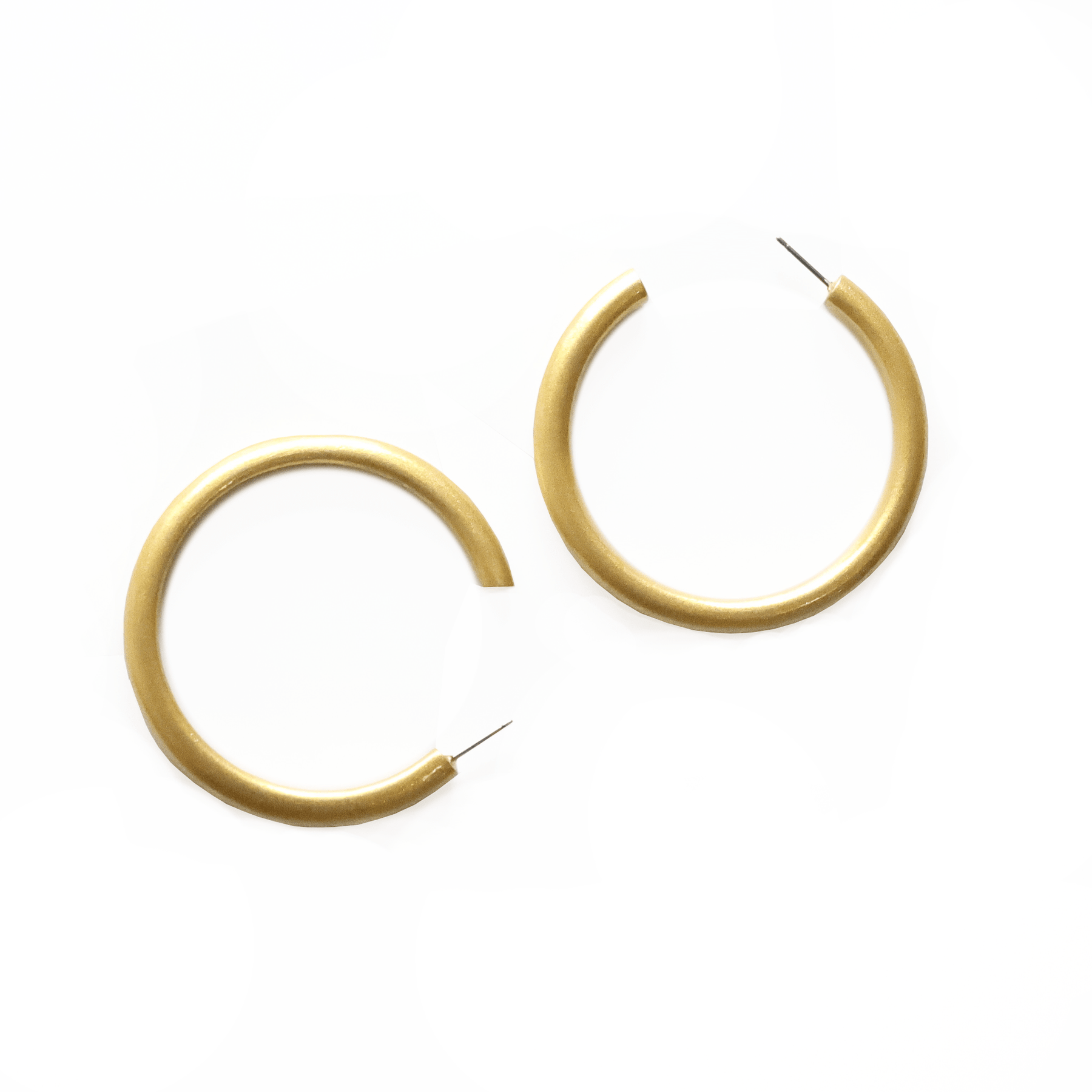 A pair of oversized metallic gold hoop earrings with a buffalo horn component, displayed against a white background.