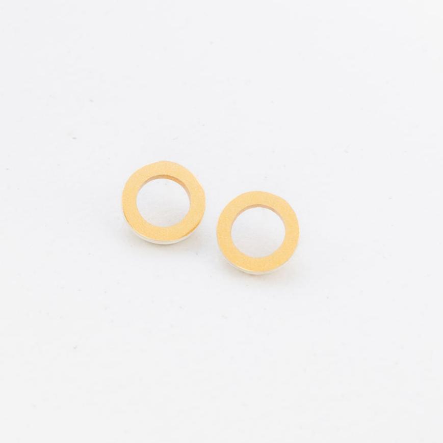A pair of gold-colored ring-shaped earrings on a white background