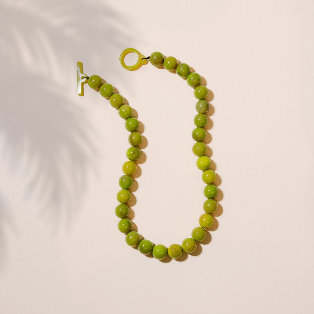 Green beaded necklace on a white background