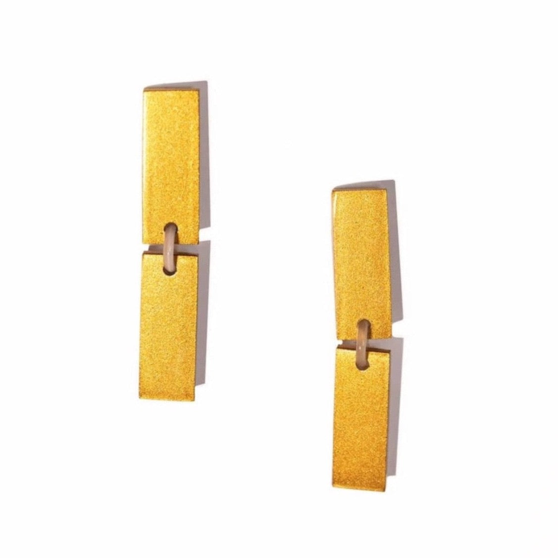 A pair of gold-colored earrings with a geometric design, made from buffalo horn and stainless steel.