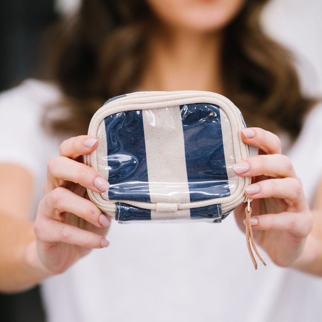 Person holding a small round pouch with a striped design