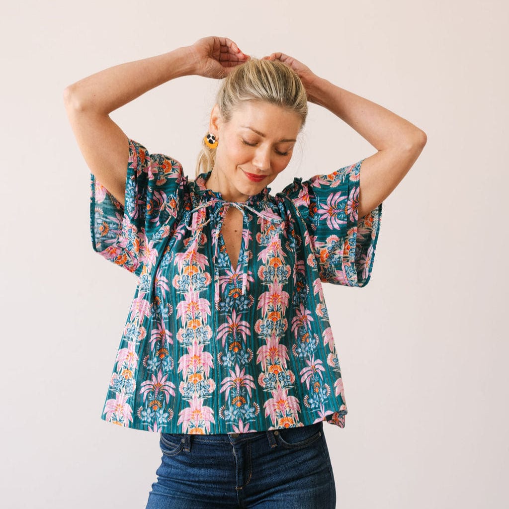Woman wearing a floral blouse with a plain background