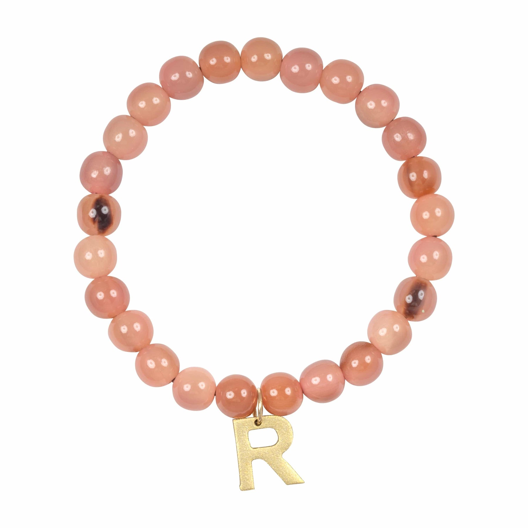 A pink bead bracelet with a gold initial charm 'R', on a white background.
