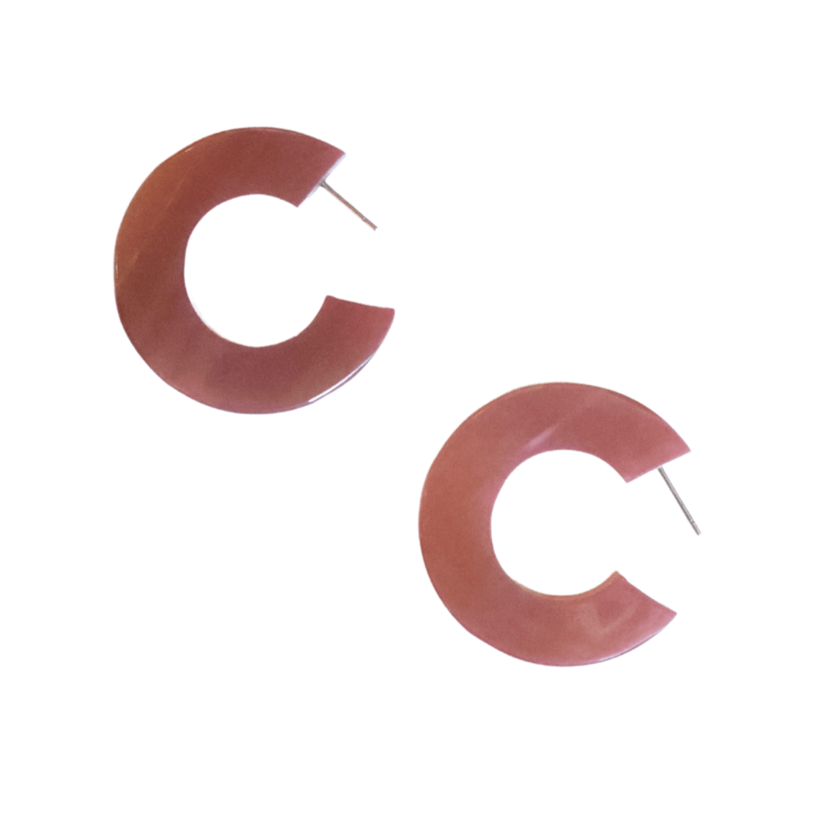 Pink earrings shaped like the letter 'C' on a white background