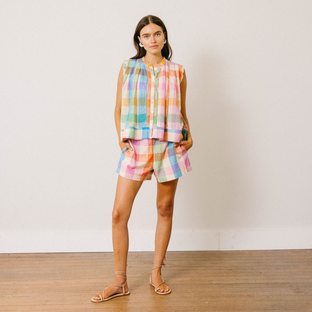 Woman wearing a colorful checkered outfit against a white background