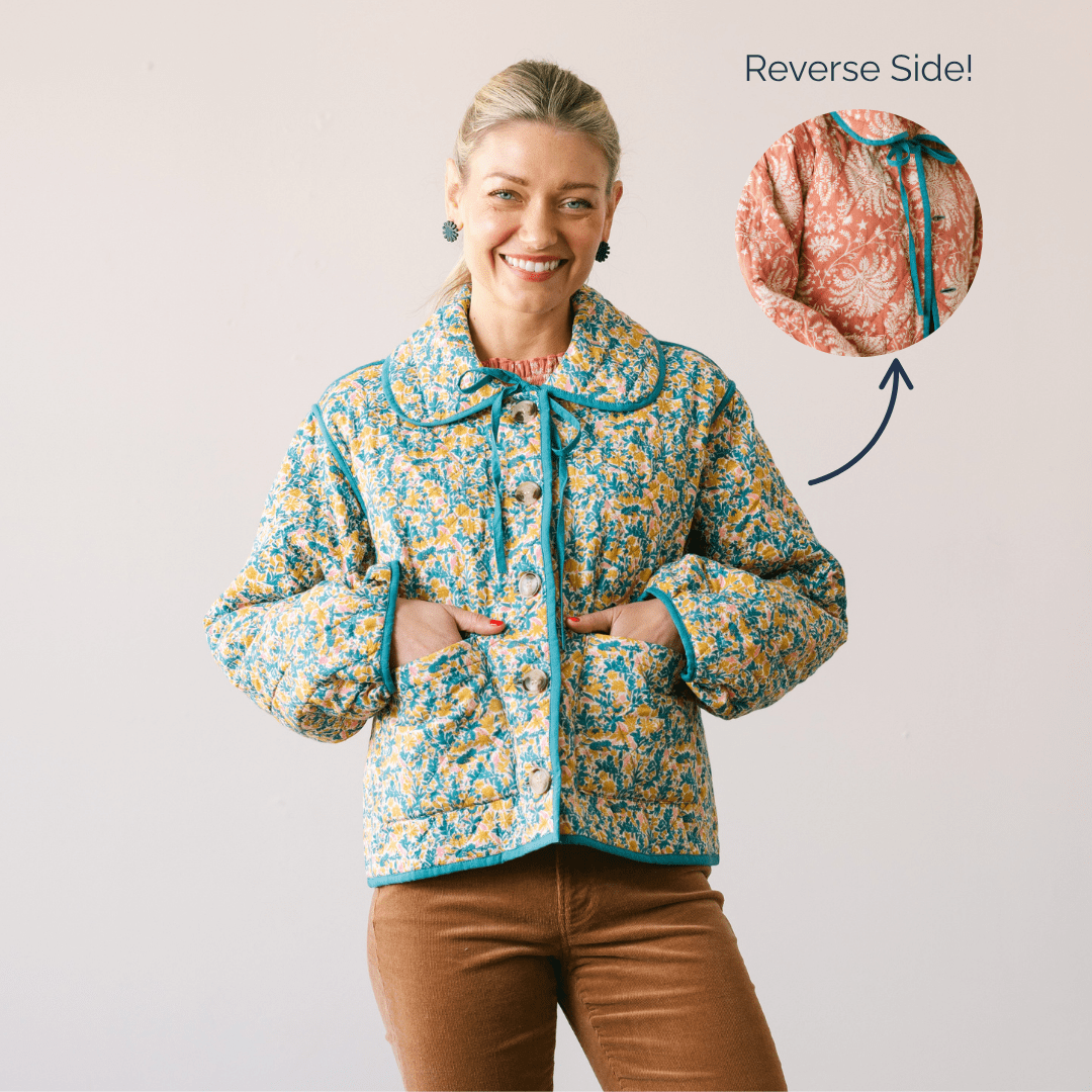Woman wearing a floral jacket with a visible reverse side pattern on a plain background
