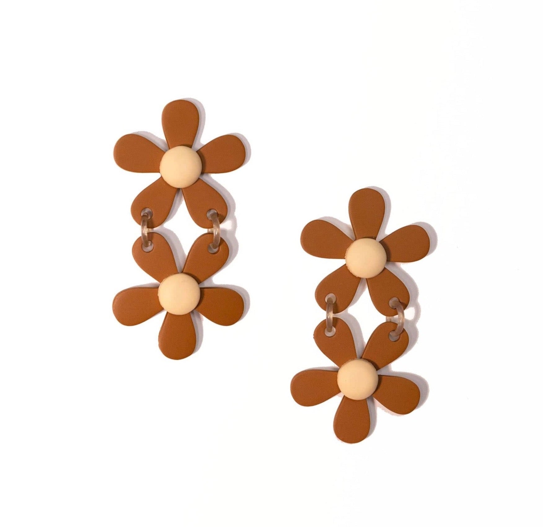 A pair of tan and white flower-shaped earrings with a matte finish, inspired by desert flowers, with a lightweight buffalo horn construction and stainless steel back.