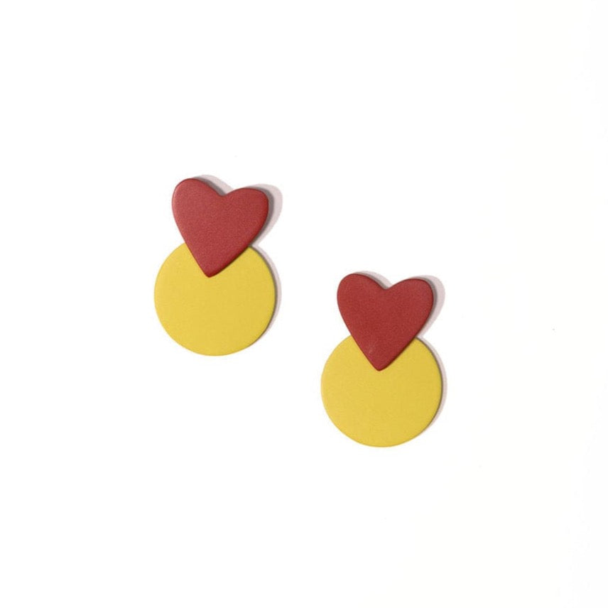 A pair of earrings featuring a red heart shape on top of a yellow circular shape, designed to represent a apple brand logo.
