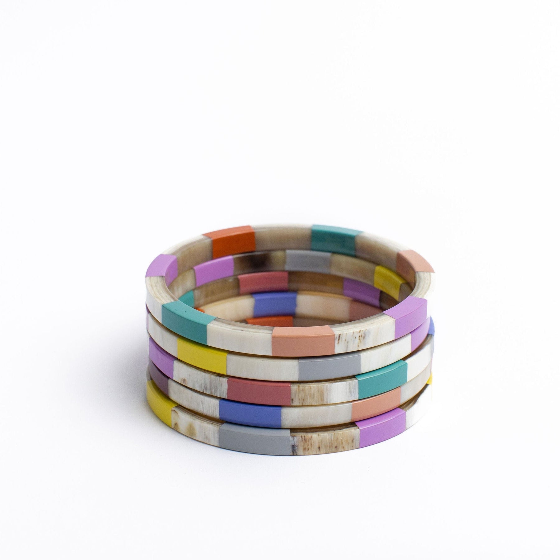 A set of colorful tile bangles in yellow, pink, purple, green, red, and natural buffalo horn colors, stacked together.