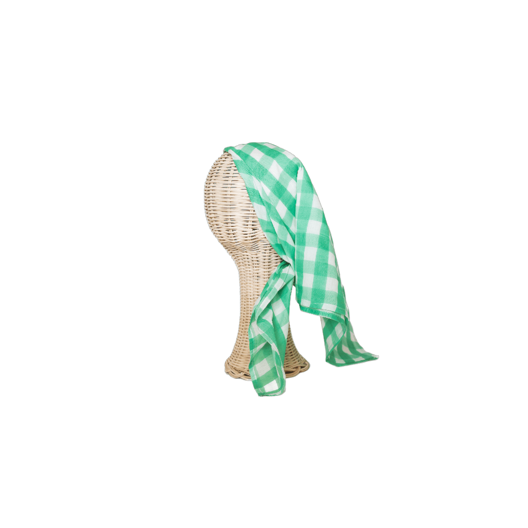 A green checkered scarf draped around a mannequin's head.